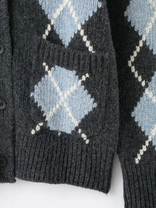 Detailed macro view of diamond pattern knit cardigan with ribbed cuffs and pocket detail