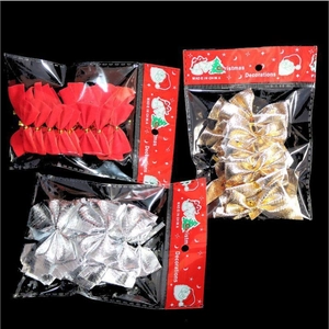 Close-up of red, gold, and silver Christmas tree bow ornaments in retail packaging