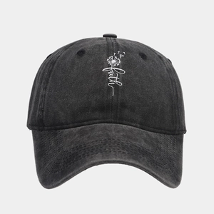 Close-up of dandelion and faith embroidery on a black washed denim baseball cap