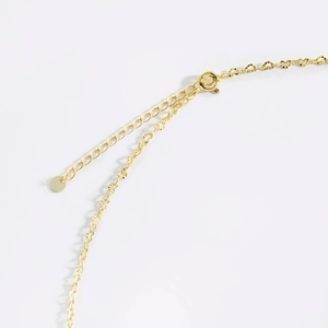 Close-up of golden S925 sterling silver chain with lobster clasp and extension links