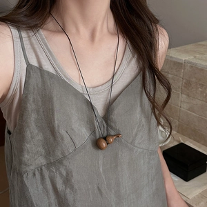 Collier minimaliste avec pendentif en bois de gourde sur une cordelette noire et lin