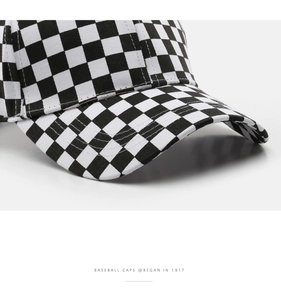 Detail of black and white checkered baseball cap showing stitching and canvas texture