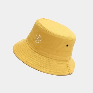 Detailed view of yellow bucket hat with S embroidery and metal ventilation eyelets