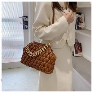 Detail of caramel brown quilted bag with gold chain strap and elegant faux leather texture
