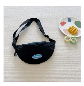 Detail of adjustable nylon strap and plastic buckle on black canvas chest bag