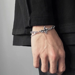Close-up of a silver titanium steel chain bracelet with a black enamel cross pendant