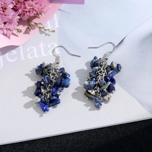 Macro detail of blue lapis lazuli stone cluster earrings with silver chain tassels