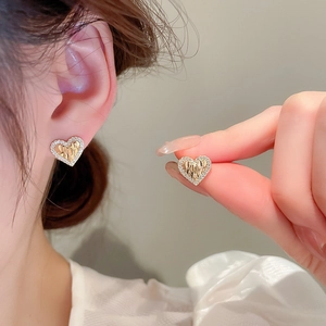 Detailed view of heart-shaped gold studs with pleated center and sparkling crystal trim