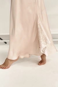 Detailed view of the luxury champagne satin dress featuring delicate white floral lace hem