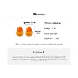 Detail of orange hairball flower earrings with silver needle posts and ABS beads