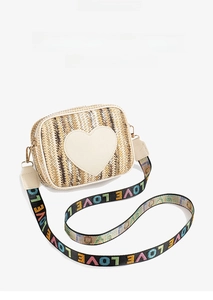 Close-up of heart-shaped leather patch on woven straw bag with colorful LOVE strap