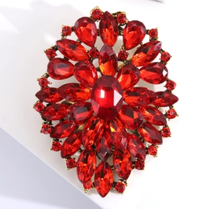Macro view of vintage alloy brooch with red crystals and rhinestones on gold finish