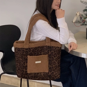 Close-up of leopard print plush tote bag with brown fleece pocket and soft texture