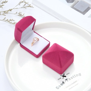 Macro detail of magenta velvet jewelry box with rose gold diamond ring inside