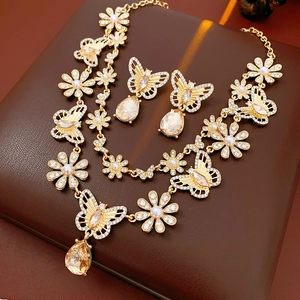 Détail d'une parure vintage dorée avec cristaux couleur champagne et perles élégantes