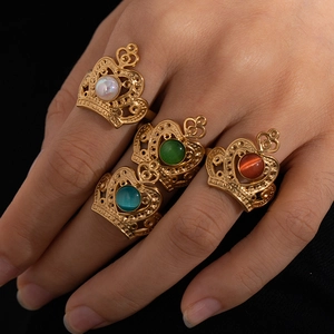 Close-up of four gold crown rings featuring white, green, blue and brown cat-eye stones