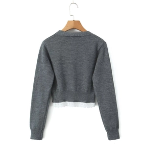 Détail du dos d'un cardigan gris en maille avec bordure en dentelle blanche élégante