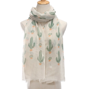 Beige summer scarf with green cactus print and fringe tassels on a mannequin