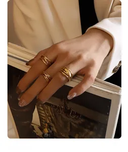Close-up of three-piece gold-plated crisscross rings set on a model's hand