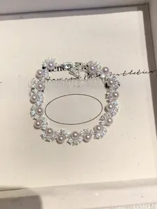 Macro shot of elegant pearl bracelet with cubic zirconia flower clusters in a box