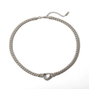 Macro shot of silver Cuban chain necklace with hollow heart pendant and lobster clasp