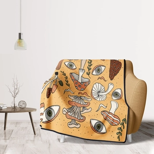 Detail of ginger flannel blanket with mushroom and eye prints on a modern sofa