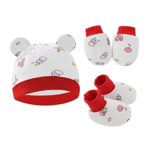 Dettaglio set neonato con cappello, guanti e scarpine con stampe ciliegie e stelle