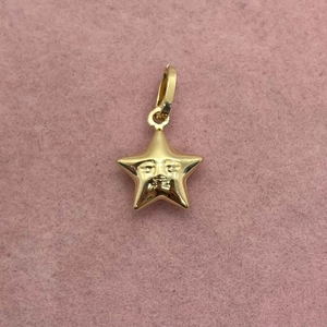 Detailed view of a gold-plated star pendant featuring a unique face relief design