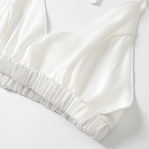 Vue détaillée d'un caraco en satin blanc avec ourlet élastique plissé et texture soyeuse