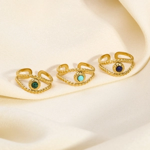 Detailed macro view of three vintage 18K gold-plated rings with colorful gemstones