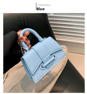 Close-up of light blue pebbled leather mini bag with beaded chain and top handle