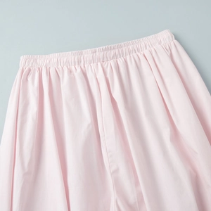 Detail shot of light pink cotton trousers showing the elastic waistband and fine fabric texture