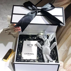 Elegant white flip-top gift box with black ribbon and raffia filler for premium packaging