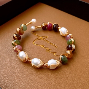 Macro detail of handmade wire-wrapped natural agate and pearl bohemian open bracelet