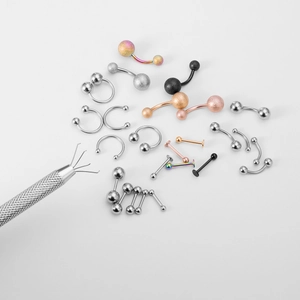Assorted body piercing jewelry including navel rings and a metal gripper tool set