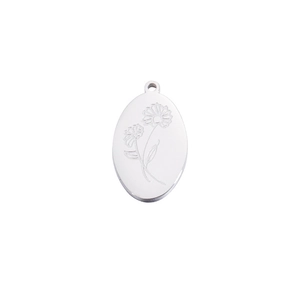 Detailed view of an oval silver pendant featuring finely engraved daisy flower patterns