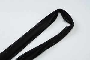 Détail du tissu en maille noire transparente avec des paillettes et ornements scintillants