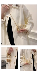 Detailed view of a mini butterfly shaped golden metal crossbody box bag with chain