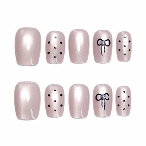 Nude cat-eye press-on nails set with elegant black polka dots and 3D pearl bow design