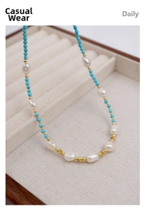 Detailed close-up of turquoise beads, freshwater pearls, and golden faceted spacers necklace