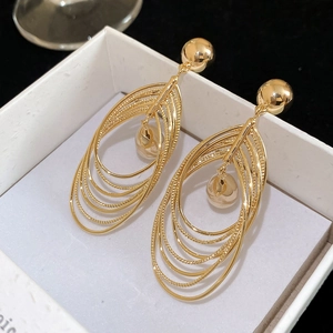 Detailed macro view of 18k gold plated multi-layer teardrop earrings in a white jewelry box