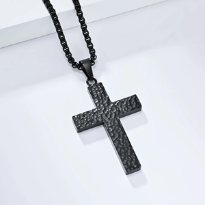 Détail du pendentif croix noire martelée en acier inoxydable avec surface à texture alvéolée