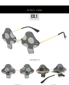 Detail view of rimless mushroom shaped sunglasses with grey polka dots and gold arms