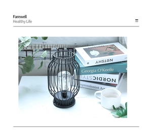 Industrial black iron lantern lamp with Edison bulb on a white marble tabletop