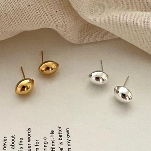 Detailed view of minimalist S925 sterling silver bean stud earrings in gold and silver