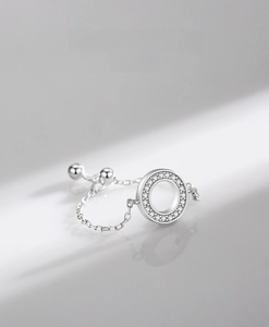 Detailed macro of a S925 sterling silver chain ring with a sparkling pavé circle charm