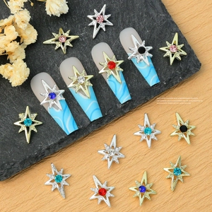 Detailed macro view of colorful rhinestone star nail art charms on metallic base