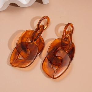 Vintage amber acrylic chain earrings with interlocking oval links on a beige background