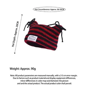Striped red and black knit beanie with cat ears and decorative bow ties at the top