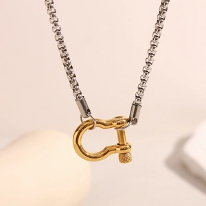 Detailed close-up of two-tone stainless steel square box chain with golden U-link pendant
